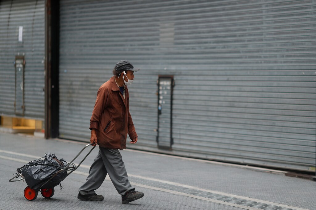 A man wearing a face mask as a preventive measure against the coronavirus disease (COVID-19) walks in front of closed shops, in Buenos Aires, Argentina May 21, 2020. REUTERS/Agustin Marcarian - RC24TG9066KW