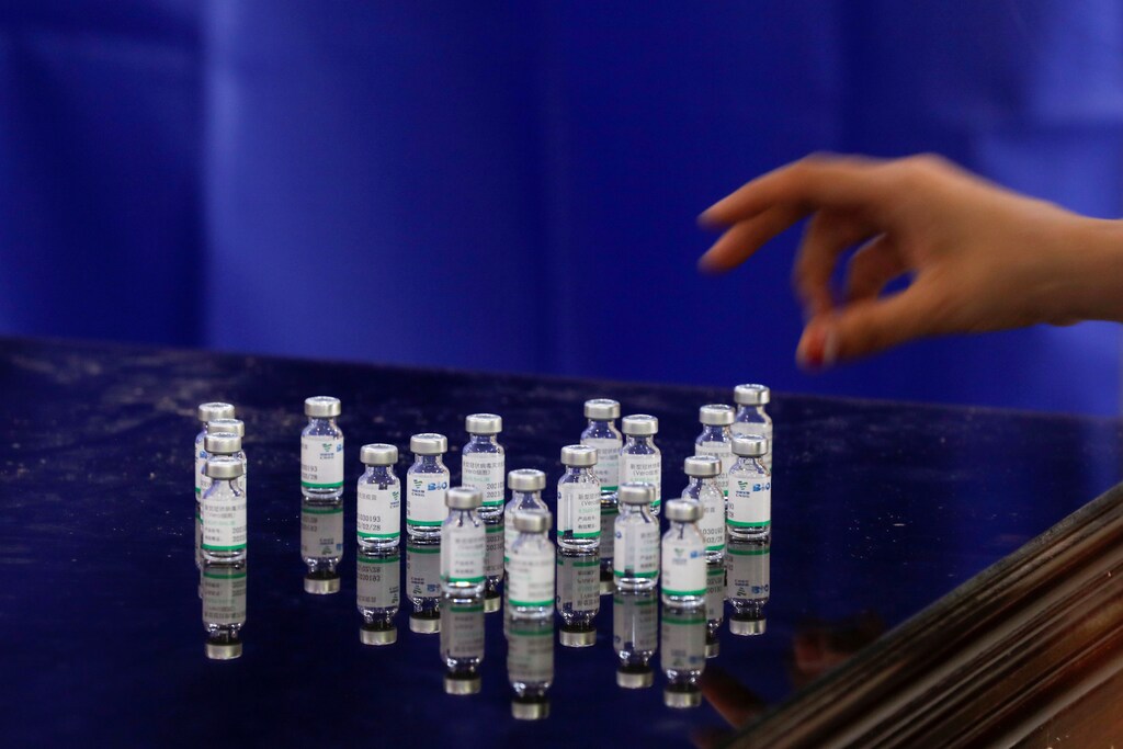 image of a health worker counting used vials of Sinopharm's coronavirus disease (COVID-19) vaccine