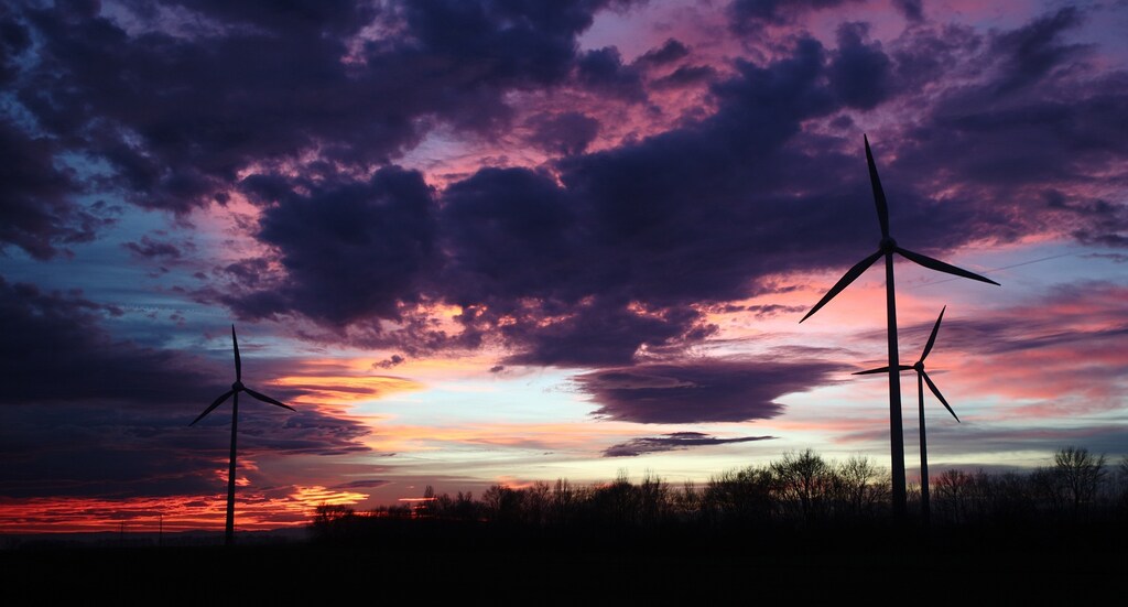 The setting sun illuminates the sky behind wind turbines of a wind park near Neusiedl am See, December 22, 2014.