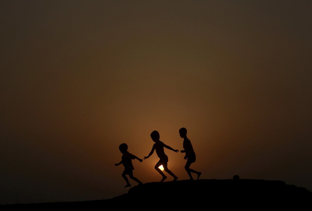 Children are silhouetted against the setting sun as they play on a ground on the outskirts of Agartala, capital of India's northeastern state of Tripura, April 23, 2015. REUTERS/Jayanta Dey TPX IMAGES OF THE DAY - GF10000070049