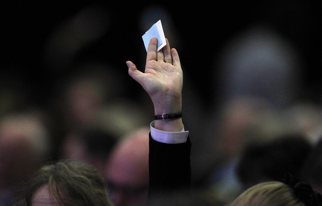 A man holds his ballot paper in the air for collection during the federation of small businesses conference in Aberdeen, Scotland March 19, 2010. REUTERS/David Moir (BRITAIN - Tags: BUSINESS SOCIETY) - GM1E63J1QFL01