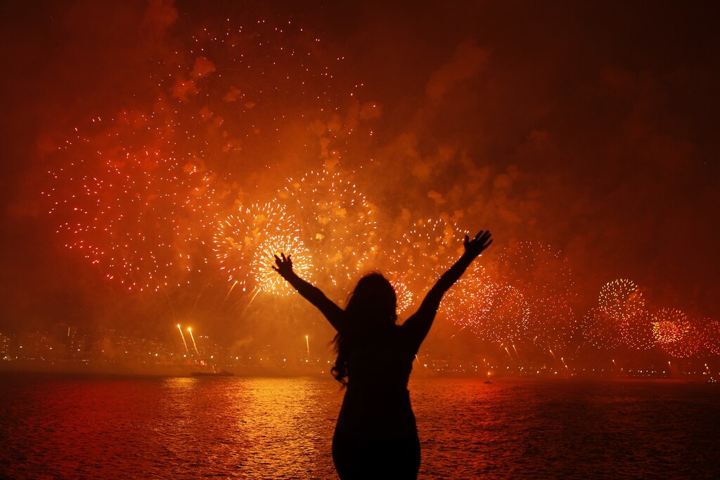 A woman celebrates the New Year as she watches fireworks exploding above Copacabana beach in Rio de Janeiro January 1, 2013. More than two million people gathered along Rio's most famous beach to witness the 20-minute display and celebrate the beginning of a new year. REUTERS/Pilar Olivares (BRAZIL - Tags: ANNIVERSARY SOCIETY TPX IMAGES OF THE DAY) FOR BEST QUALITY IMAGE: ALSO SEE GF2E96N16UJ01. - GM1E9110V2601