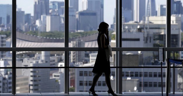 A woman uses her mobile phone at an office building in Tokyo July 21, 2015. Two in five Japanese firms plan to boost capital spending this business year, and more than a third of those say it is because of rising demand, a Reuters poll showed, pointing to a pickup in confidence about the economy. Picture taken July 21, 2015. REUTERS/Toru Hanai