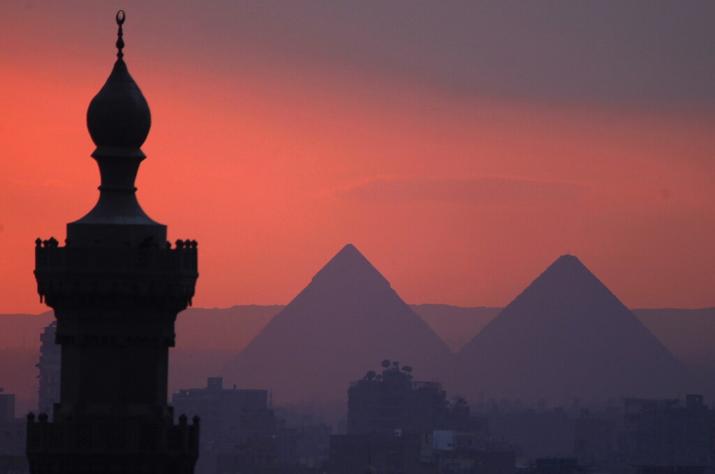 The sun sets on the minarets and the Great Pyramids of Giza (R) in Old Cairo December 31, 2013. REUTERS/Amr Abdallah Dalsh (EGYPT - Tags: CITYSCAPE SOCIETY) - RTX16Y99
