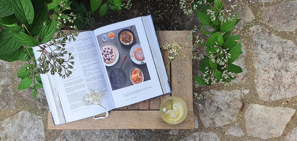Magnus Nilsson's 'The Nordic Cookbook' is displayed to a recipe on a table outside