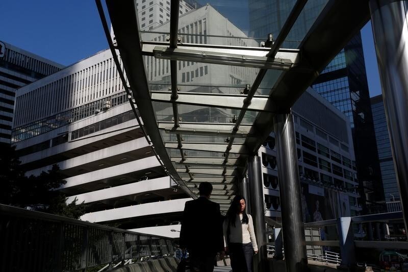 People walk on a footbridge in front of a multi-story car park, which will be auctioned with value as high as $2.2 billion in the first quarter of 2017, the first sale of commercial land in the Central business district in more than 20 years, in Hong Kong, China January 27, 2017. REUTERS/Bobby Yip - RTSXM0I