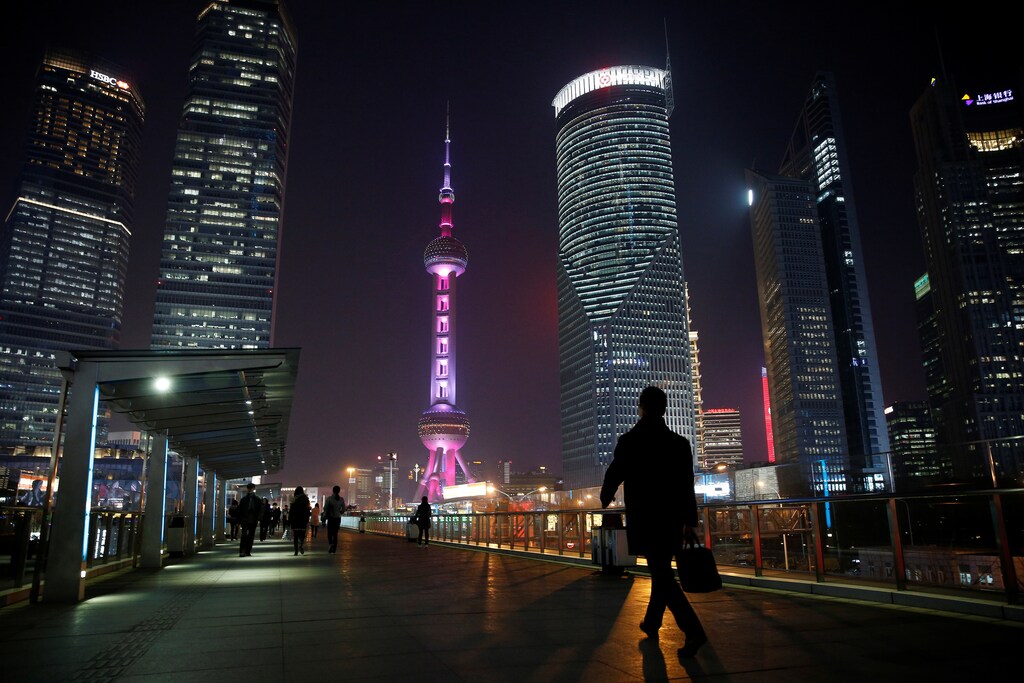 A man walks on a bridge in the financial district of Pudong in Shanghai, China.