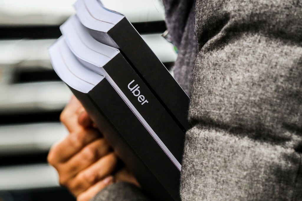 An investor walks out of the Uber IPO roadshow with documents in hand at a hotel in Manhattan, New York, New York, U.S., April 30, 2019. REUTERS/Jeenah Moon - RC1A4E69E090