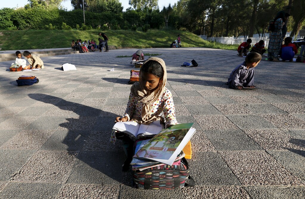 Children study between their classes at a local park in Islamabad April 22, 2015.