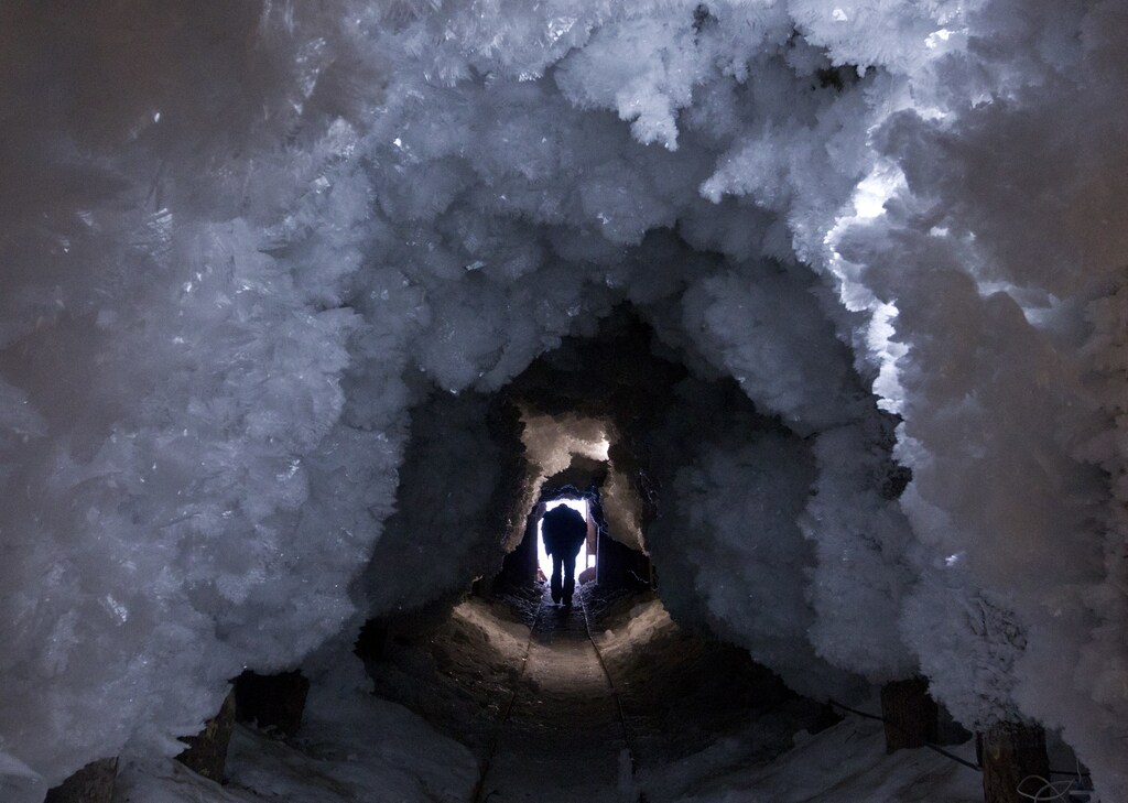 A man walks through a tunnel formed from crystals of permafrost outside the village of Tomtor in the Oymyakon valley in northeast Russia, January 28, 2013. The coldest temperatures in the northern hemisphere since the beginning of the 20th century have been recorded in the Oymyakon valley, known as the 'Pole of Cold', where according to the United Kingdom Met Office a temperature of -67.8 degrees Celsius (-90 degrees Fahrenheit) was registered in 1933. REUTERS/Maxim Shemetov (RUSSIA - Tags: SOCIETY ENVIRONMENT) - LM2E92F1AO201