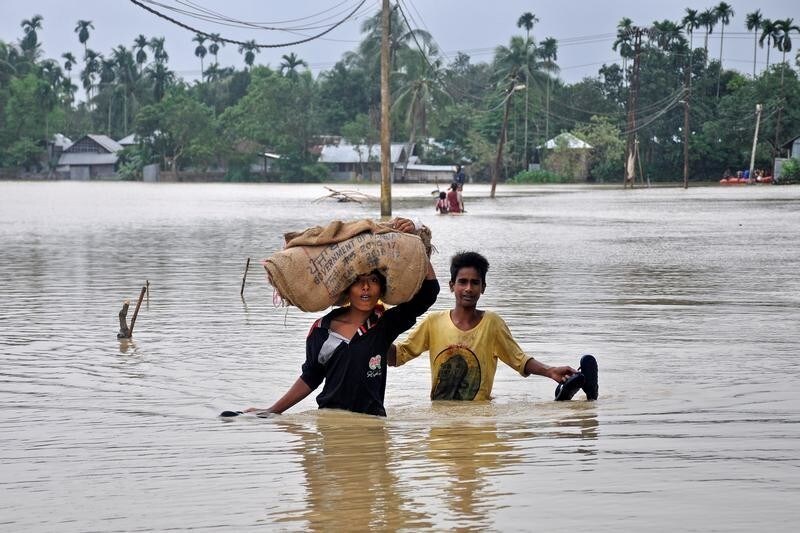 Boys wade through a flooded village on the outskirts of Agartala, India, October 22, 2017.