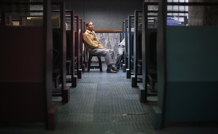 A stockbroker sits outside his booth while monitoring stock prices on a computer screen, during a trading session at the Karachi Stock Exchange January 19, 2012. Pakistani stocks ended lower on Thursday as investors booked profit in blue chip companies such as Oil and Gas Development Co Ltd (OGDCL) . The Karachi Stock Exchange's benchmark 100-share index ended 0.28 percent, or 32.12 points, lower at 11,515.59 points. On Wednesday, the KSE-index ended 2.15 percent higher at 11,547.71, its highest close since December 1. REUTERS/Athar Hussain (PAKISTAN - Tags: BUSINESS)