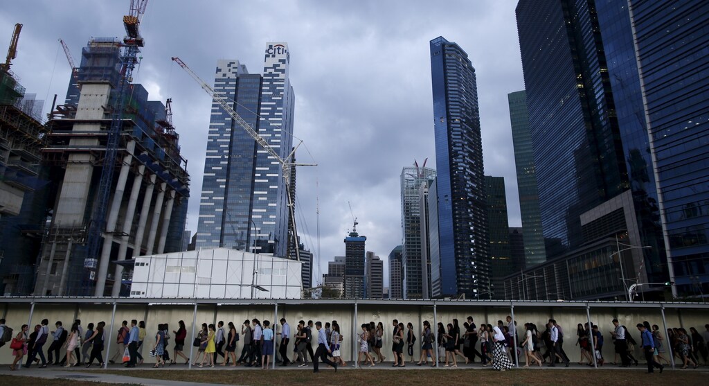 Commuters walk to the train station during evening rush hour in the financial district of Singapore March 9, 2015.