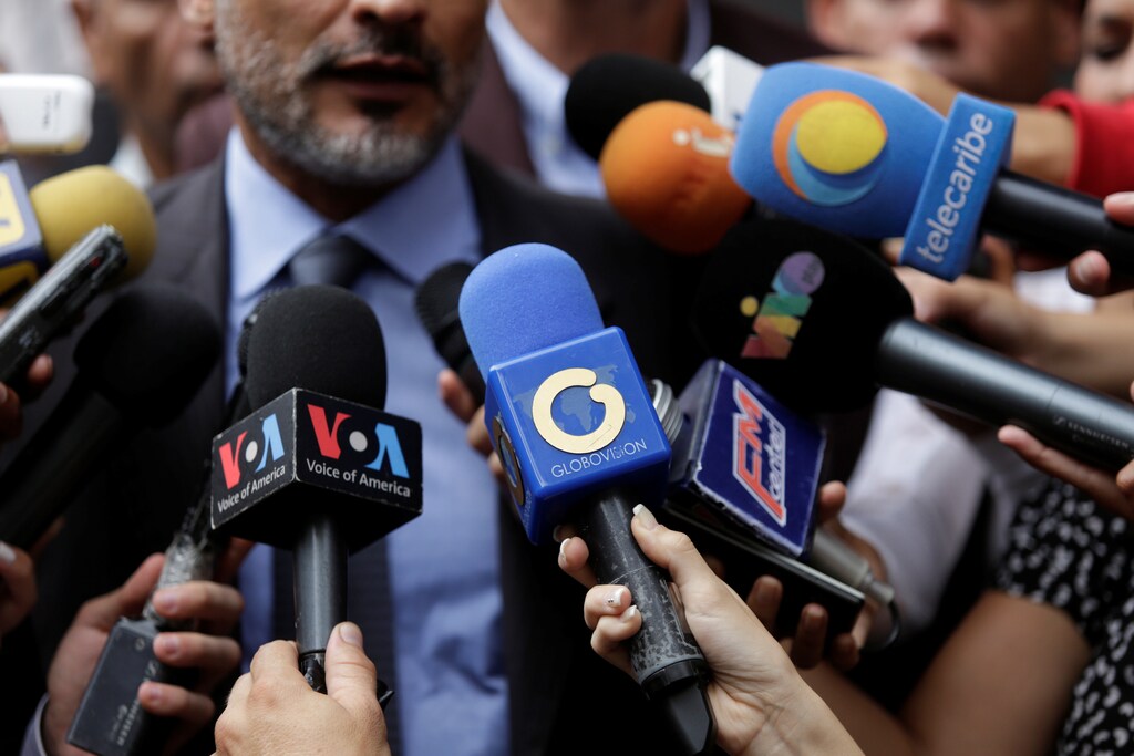 The logo of Globovision TV channel is seen on a microphone (C) used by a TV journalist among other microphones during a news conference in Caracas, Venezuela May 16, 2017. Picture taken May 16, 2017. REUTERS/Marco Bello - RTX37SFQ