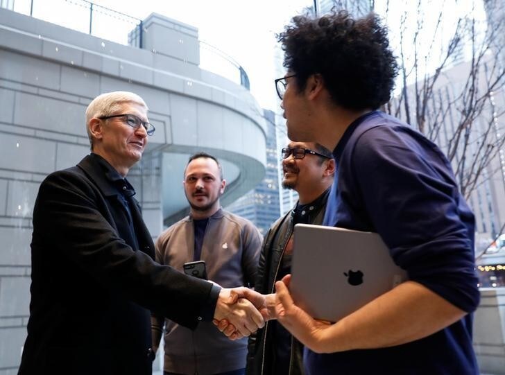 Tim Cook, Chief Executive Officer of Apple Inc., shakes hands with an employee as he visits the Apple Store in Chicago, Illinois, U.S., March 27, 2018. REUTERS/John Gress