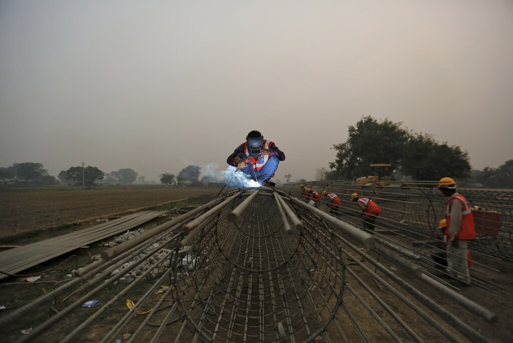 Labourers work at the construction site of a bridge being built for metro rail in New Delhi, India, November 30, 2015.