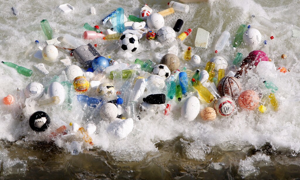 Sports balls, and plastic bottles and other litter is accumulated by currents in the Tiber River in central Rome February 15, 2008. REUTERS/Alessandro Bianchi (ITALY) - GM1DXGSUSLAA