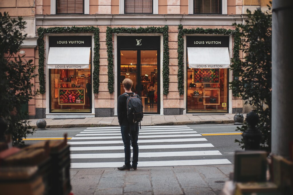 A person looks across a street at a high-end fashion shop.
