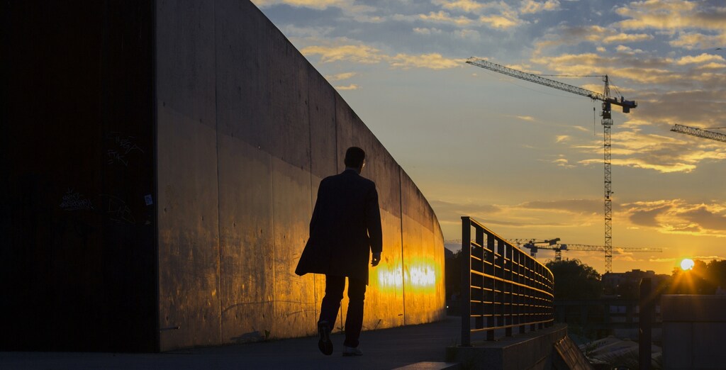 A man walks along the embankment of the river Spree during sunset in Berlin, September 13, 2013. REUTERS/Thomas Peter (GERMANY - Tags: CITYSCAPE BUSINESS CONSTRUCTION SOCIETY TPX IMAGES OF THE DAY) - RTX13KDN