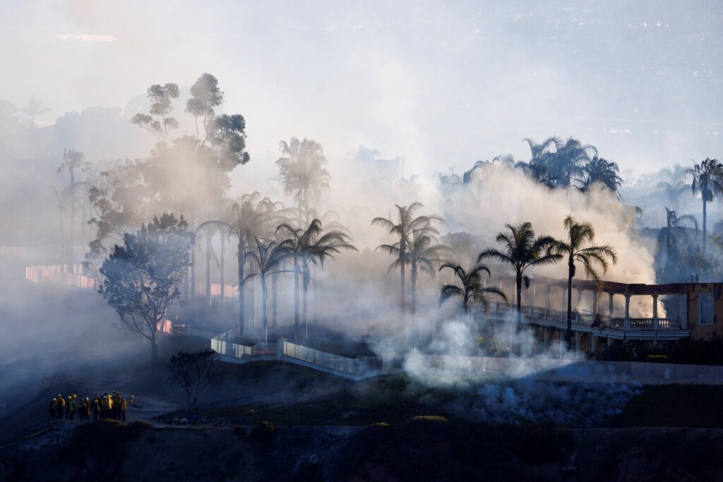 Multi-million dollar home smolders at the top of a canyon hillside in the aftermath of the Coastal Fire, a wildfire in Laguna Niguel, California, U.S., May 12, 2022. REUTERS/Mike Blake
