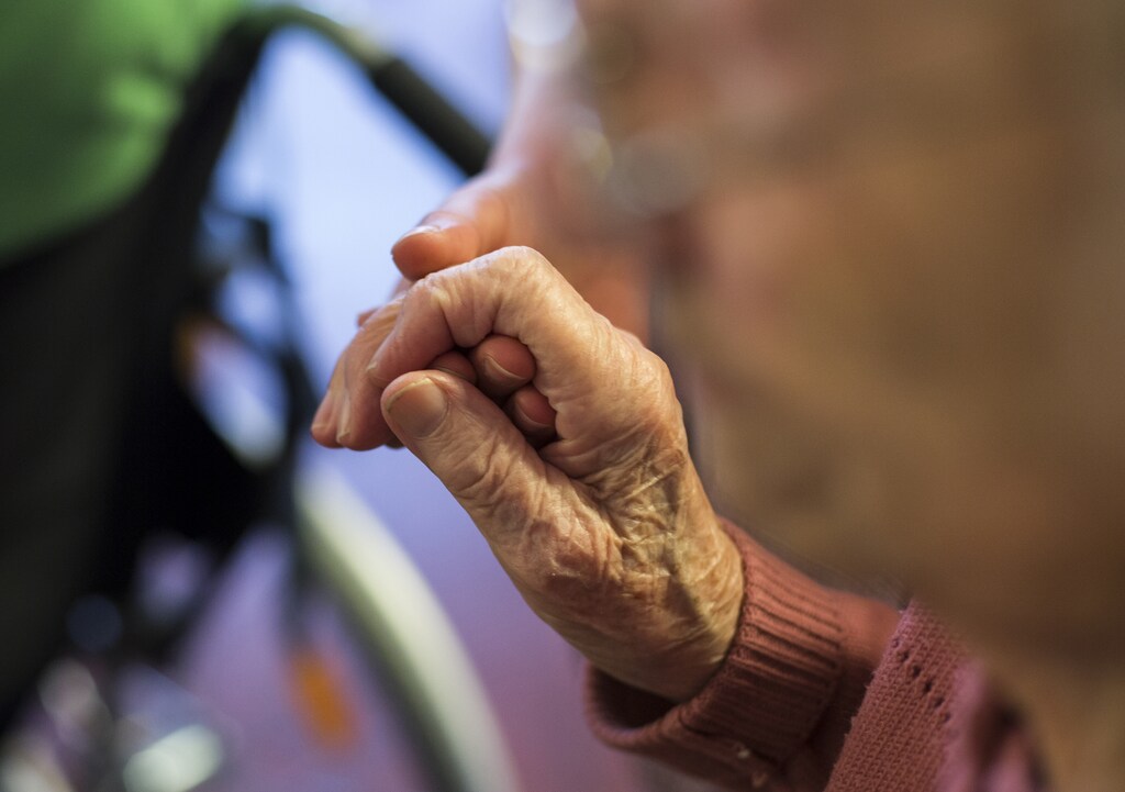 A resident holds the hand of a nurse at the SenVital elderly home in Kleinmachnow outside Berlin May 28, 2013. Facing an acute shortage of skilled applicants among its own workforce, German institutions in the care sector increasingly turn to southern European countries to hire trained nursing staff who are willing to work abroad despite the language barrier in order to escape unemployment at home. The SenVital home for the elderly outside Berlin has accepted five qualified nurses from Spain as their staff, providing eight months of language training and additional care schooling needed to attain the German nursing concession. Some 100 Spaniards applied for the ten vacancies SenVital had advertised across its various houses. REUTERS/Thomas Peter (GERMANY - Tags: HEALTH BUSINESS EMPLOYMENT) - RTX103ZD