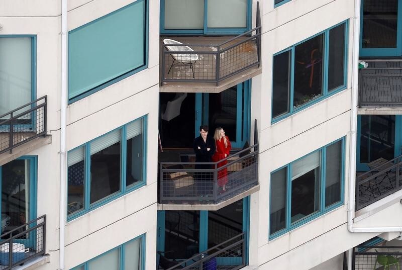 People stand on their balconies in an apartment building in New Jersey overlooking the Hudson River during the outbreak of coronavirus disease (COVID-19) in New York City, U.S., March 30, 2020. REUTERS/Mike Segar TPX IMAGES OF THE DAY - RC2GUF93G33J