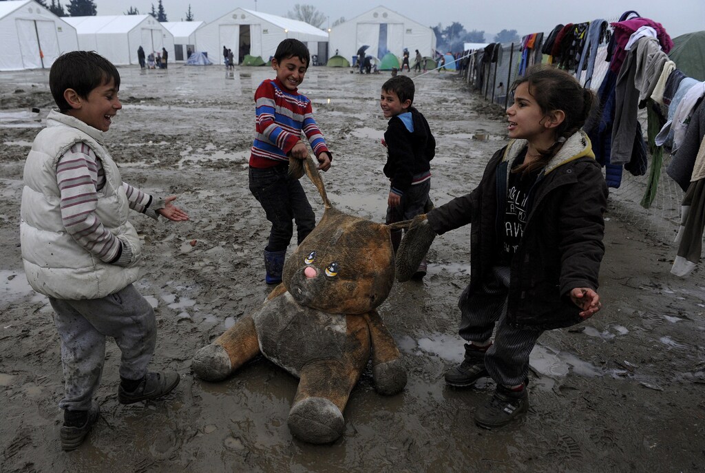 Refugee children play with a stuffed toy at a muddy makeshift camp at the Greek-Macedonian border, near the village of Idomeni, Greece March 15, 2016. REUTERS/Alexandros Avramidis TPX IMAGES OF THE DAY - GF10000346539