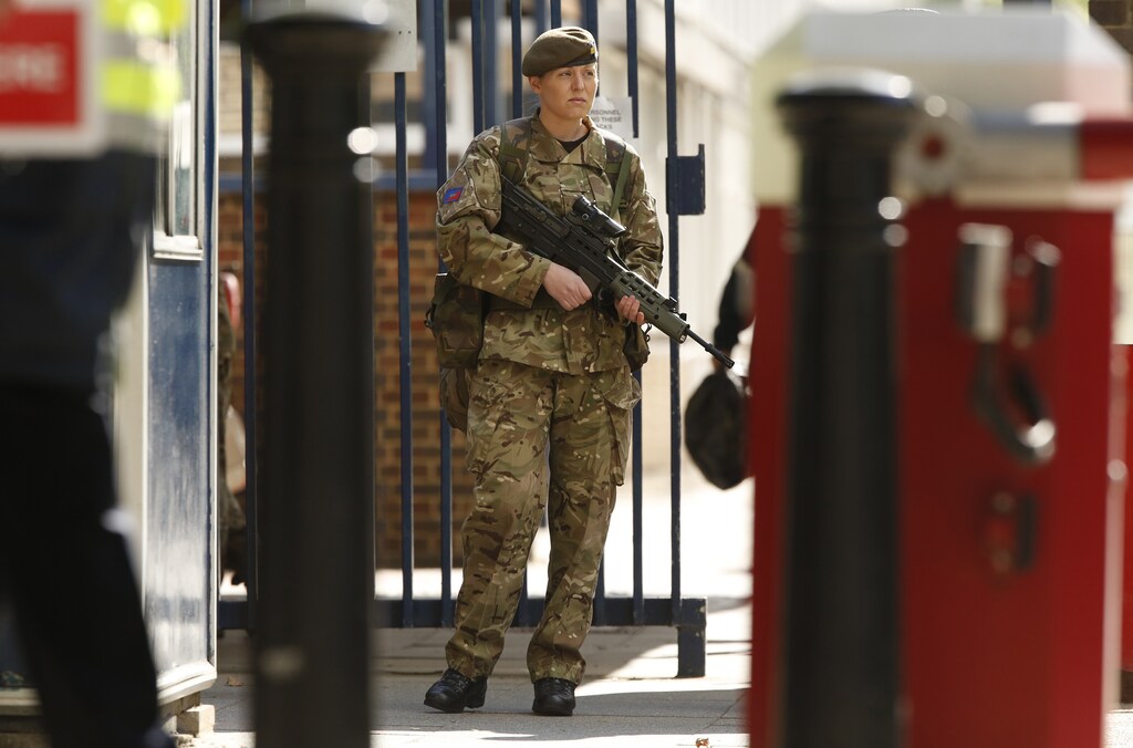 A female soldier stands outside the Royal Military Barracks, near the scene where a British soldier was killed in Woolwich, southeast London May 23, 2013. The soldier was hacked to death on Wednesday by two men shouting Islamic slogans in a south London street, in what Prime Minister David Cameron said appeared to be a terrorist attack. REUTERS/Luke MacGregor (BRITAIN - Tags: CRIME LAW MILITARY POLITICS SOCIETY) - LM1E95N0P0Y01