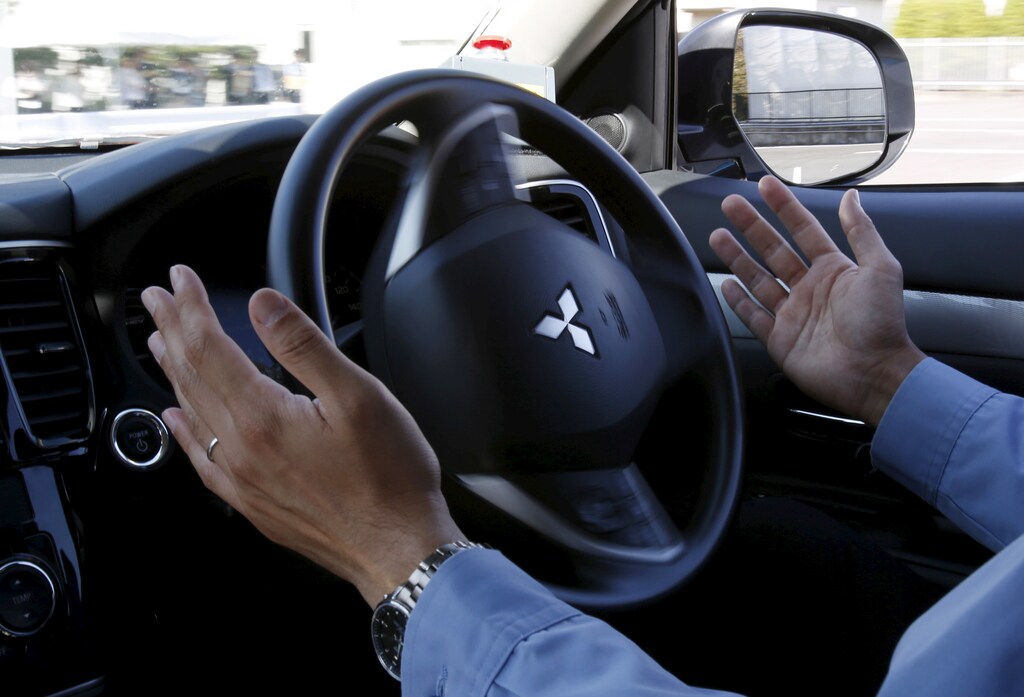 A staff member of Mitsubishi Electric drives its self-driving concept car "EMIRAI3 xAUTO" using the hands-free function during a media preview in Kamakura, south of Tokyo, Japan, October 14, 2015.
