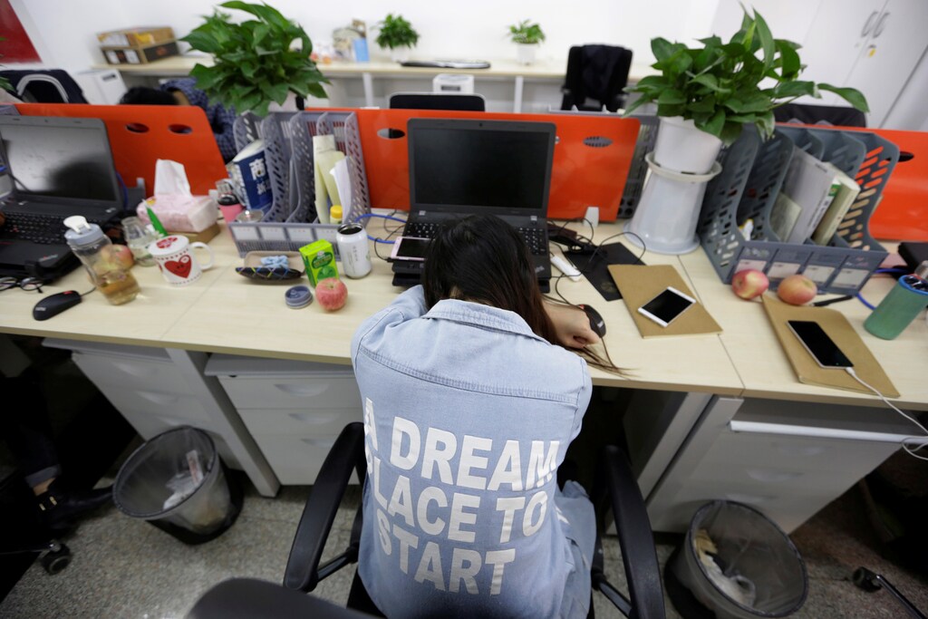 Yang Juan, an employee at Goopal Group, takes a nap in her seat after lunch, in Beijing, China, April 21, 2016. Office workers sleeping on the job is a common sight in China, where a surplus of cheap labour can lead to downtime at work. But in China's technology sector, where business is growing faster than many start-up firms can hire new staff, workers burn the midnight oil to meet deadlines and compete with their rivals. Some companies provide sleeping areas and beds for workers to rest during late nights. REUTERS/Jason Lee SEARCH "JASON SLEEP" FOR THIS STORY. SEARCH "THE WIDER IMAGE" FOR ALL STORIES - RTX2DQ8T