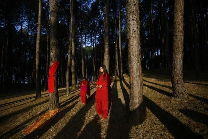 Devotees stand in the sun before performing religious rituals during the Swasthani Bratakatha festival, in the woods of Changu Narayan in Bhaktapur, January 31, 2015. During the month long festival, devotees recite one chapter of a Hindu tale daily from the 31-chapter sacred Swasthani Brata Katha book that is dedicated to God Madhavnarayan and Goddess Swasthani, alongside various other gods and goddesses and the miraculous feats performed by them. The devotees also go on pilgrimages to various temples, perform religious rituals, take a holy bath in the rivers and fast for a month, especially among women who believe fasting helps in their family's well-being or in getting them a good husband. REUTERS/Navesh Chitrakar (NEPAL - Tags: RELIGION SOCIETY TPX IMAGES OF THE DAY)