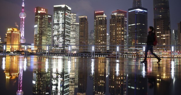 A woman walks at the Bund in front of the financial district of Pudong in Shanghai March 5, 2015. China aims to grow its economy by around 7 percent in 2015 and to keep consumer inflation at around 3 percent, Premier Li Keqiang said in remarks prepared for delivery at today's opening of the annual meeting of parliament, the National People's Congress.