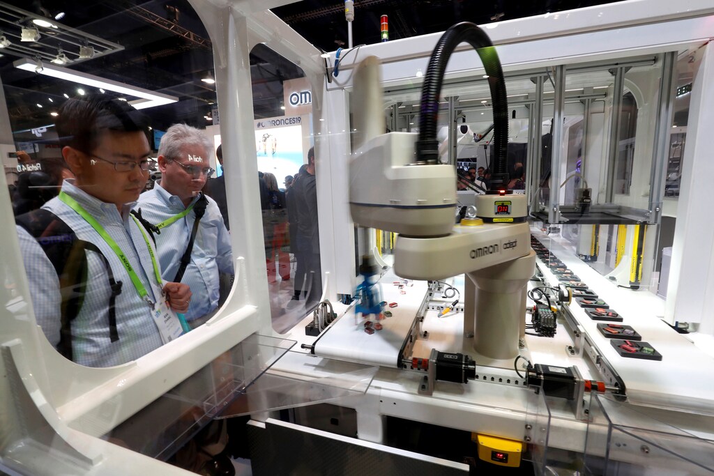 Attendees look over a demonstration of industrial robots at the Omron booth during the 2019 CES in Las Vegas, Nevada, U.S. January 9, 2019. REUTERS/Steve Marcus - RC16CDA80100