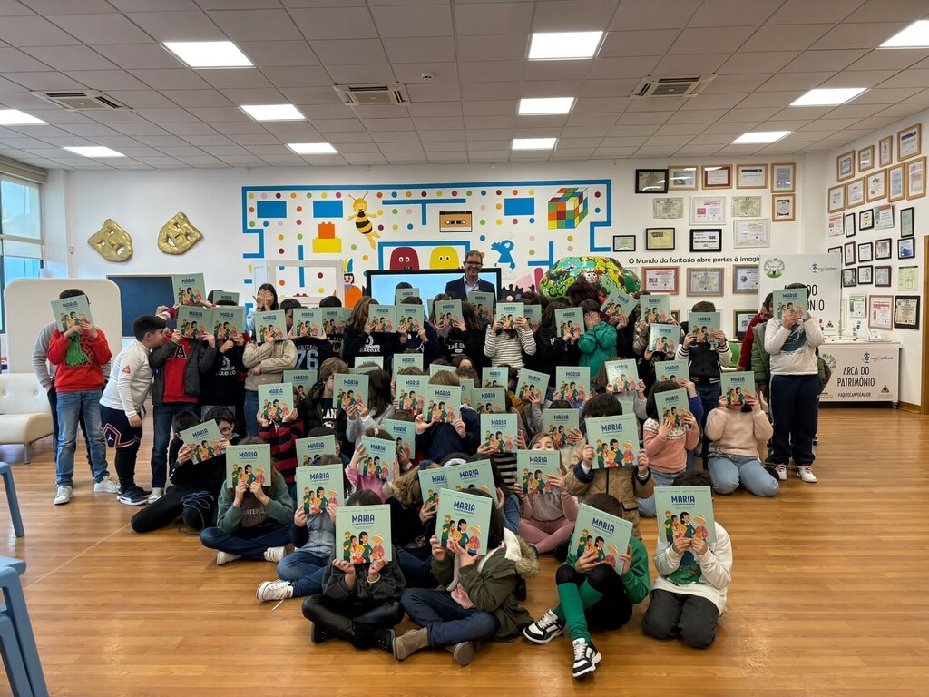 Los niños del Hub de Lisboa sostienen un libro sobre educación financiera.