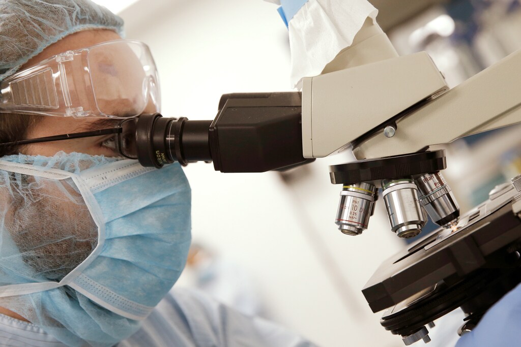 Manufacturing Associate Theodore Szmurlo views a cell sample with a microscope as he works in the cell culture room where they are working on developing a vaccine for the Zika virus based on production of recombinant variations of the E protein from the Zika virus at the Protein Sciences Inc. headquarters in Meriden, Connecticut, U.S., June 20, 2016. Picture taken June 20, 2016. REUTERS/Mike Segar - S1BEUEYZFVAC