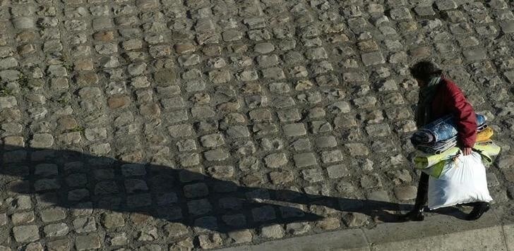 A homeless woman casts a long shadow on a cobblestone path as shecarries bags with her belongings by the River Seine in Paris, December7, 2003. As winter temperatures dropped to freezing across much ofFrance over the weekend, 62 departments have put a winter emergencyplan into action which provides greater social services for thehomeless.NO RIGHTS CLEARANCES OR PERMISSIONS ARE REQUIRED FOR THIS IMAGE. REUTERS/John Schults JES