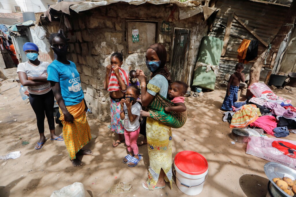 Children wearing face masks stand listening to their friends outside their shelters, amid the spread of the coronavirus disease (COVID-19), in Liberte 6 Baraka district of Dakar, Senegal May 2, 2020. REUTERS/Zohra Bensemra - RC2GGG93NMAL