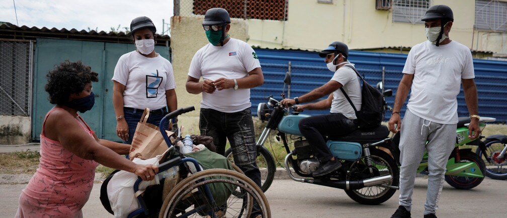 Bikers deliver donated food to a woman with a disability in Havana, Cuba.