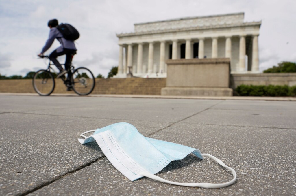 As the national death toll from the coronavirus disease (COVID-19) nears 100,000, a cyclist passes a discarded face mask in front of the Lincoln Memorial in Washington, U.S., May 27, 2020. REUTERS/Kevin Lamarque - RC24XG906RRC