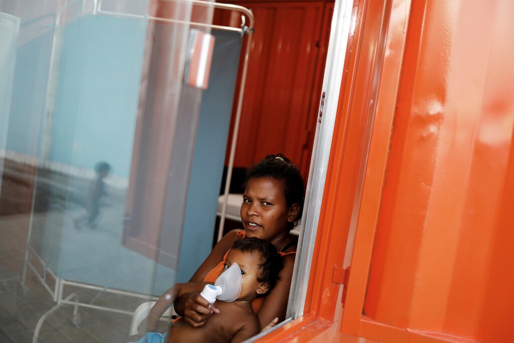 An indigenous Warao child from the Orinoco Delta in eastern Venezuela, receives nebulizer therapy by his mother at a shelter in Pacaraima, Roraima state, Brazil November 15, 2017. Picture taken November 15, 2017. REUTERS/Nacho Doce - RC184445D650
