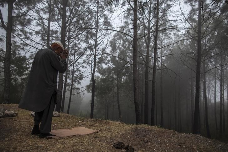 A man prays in the mist on Margalla Hills in Islamabad November 6, 2013. REUTERS/Zohra Bensemra (PAKISTAN - Tags: SOCIETY RELIGION ENVIRONMENT TPX IMAGES OF THE DAY)