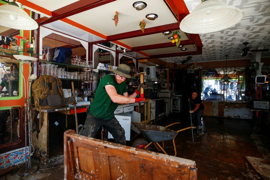 Volunteer Ole Oberlaender and Romina Mueller work to clean an ice cream parlor affected by floods caused by heavy rainfalls in the center of Bad Muenstereifel, Germany, July 18, 2021. REUTERS/Thilo Schmuelgen - RC20NO9OUGW7