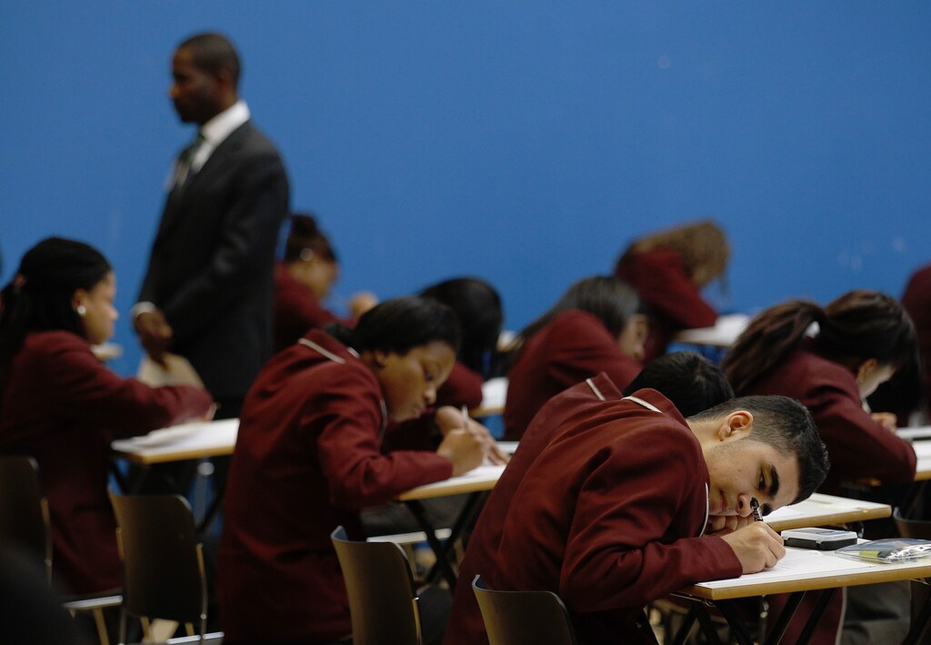 An invigilator monitors pupils during a GCSE mathematics exam at the Harris Academy South Norwood in south east London, March 2, 2012 REUTERS/Luke MacGregor