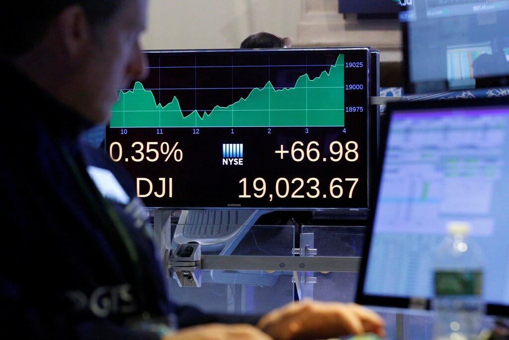 A trader works inside a post as a screen shows the Dow Jones Industrial Average after the close of trading on the floor of the New York Stock Exchange (NYSE) in New York City, U.S., November 22, 2016. REUTERS/Brendan McDermid - RTSSVDJ