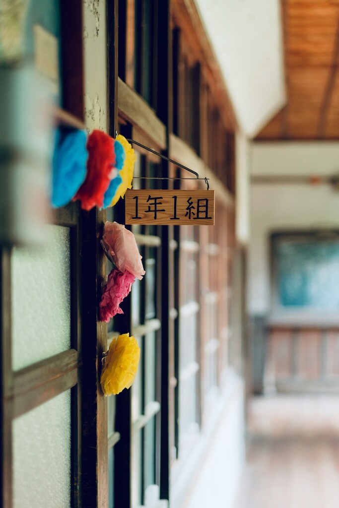 Red, blue and yellow hanging decor on school building: Repurposing closed schools revitalizes ageing communities in Japan
