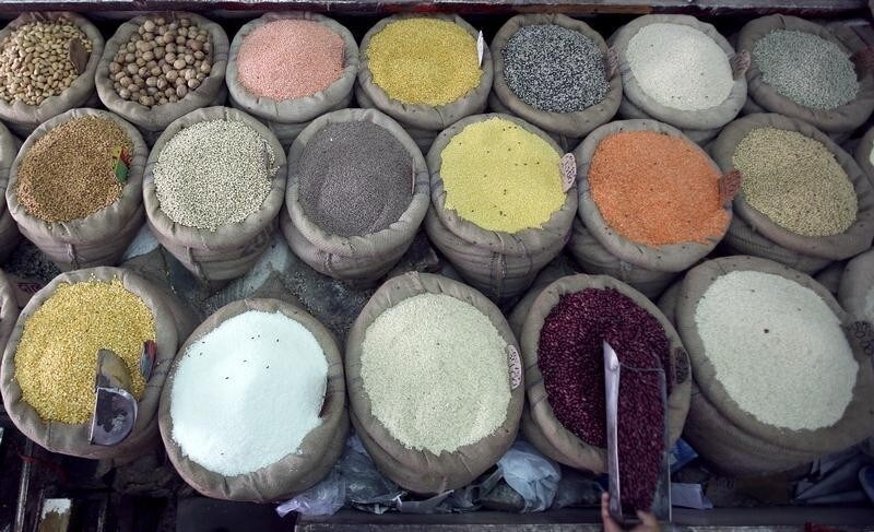 A retail trader scoops kidney beans at his shop in Jammu May 30, 2008. Surprisingly strong Indian growth and a jump in inflation above 8 percent put an interest rate rise back on the agenda on Friday, although many analysts thought the Reserve Bank of India would remain focused on cash management.