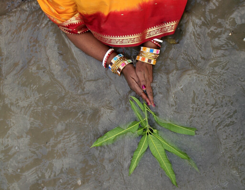 A Hindu woman performs ritual as she worships the Sun god on the banks of the river Ganges on the occasion of Chhat Puja in the eastern Indian city of Kolkata November 4, 2008. Hindu devotees fast all day for the betterment of their family and society during the festival and take a cleansing dip in the holy river Ganges. REUTERS/Jayanta Shaw (INDIA) BEST QUALITY AVAILABLE - GM1E4B41UEB01
