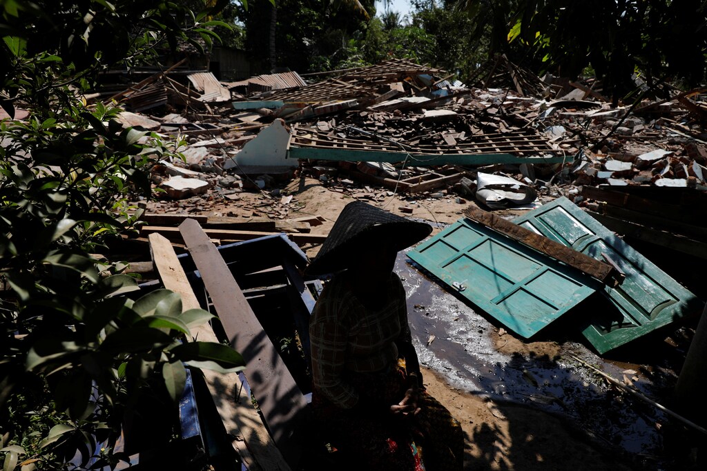 A woman sits near the ruins of her house at Kayangan district after earthquake hit on Sunday in North Lombok, Indonesia, August 7, 2018. REUTERS/Beawiharta - RC17FE26A100
