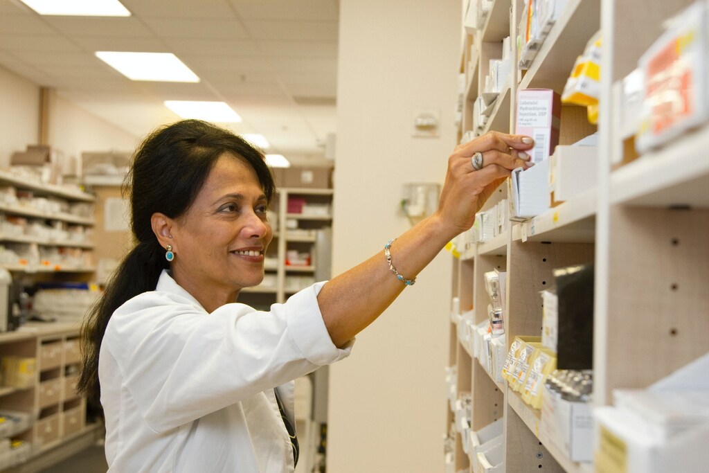this woman is selecting medicine from a pharmacy. Medication can be used to treat a range of chronic diseases, but some countries are struggling with access.