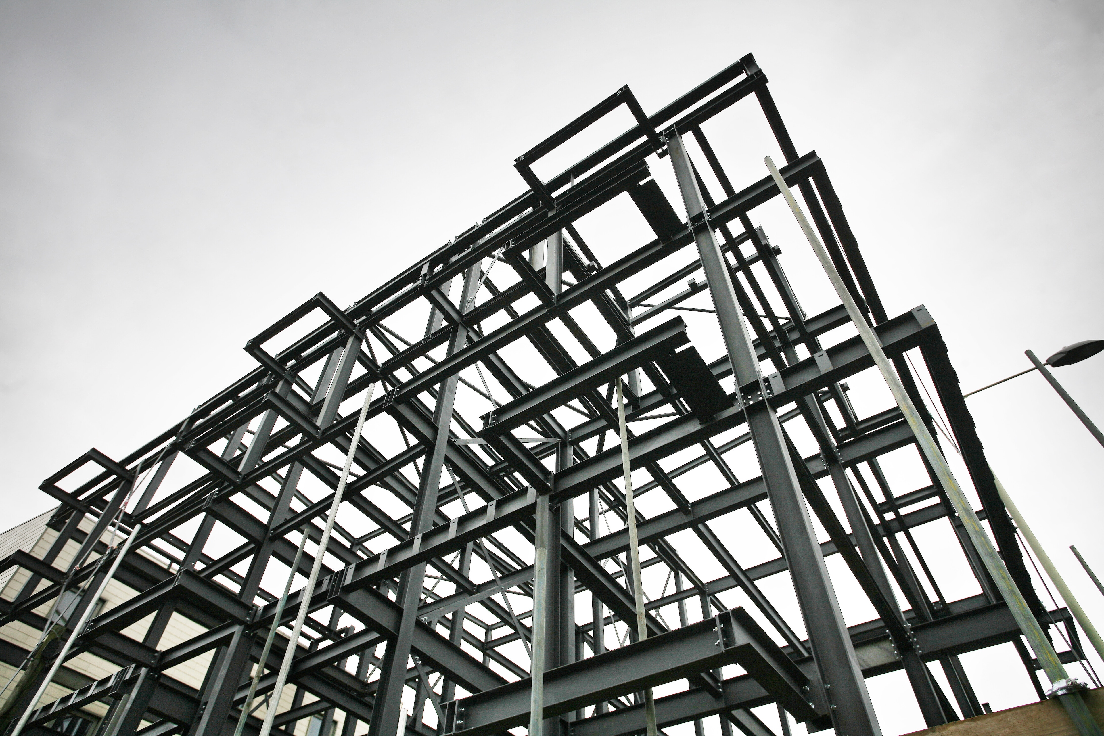 Shot of steel frame made of rsjs on a construction site in cloudy weather, illustrating the need to decarbonize the industry